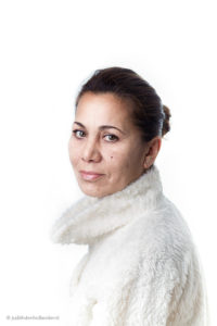 High key Studioportret | Jonge vrouw met wit 'bont' jasje tegen witte achtergrond | Fotografie Judith den Hollander.