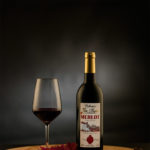 Rode wijnfles en wijnglas tegen een donkere achtergrond gefotografeerd - Fotostudio JDH Wittem.