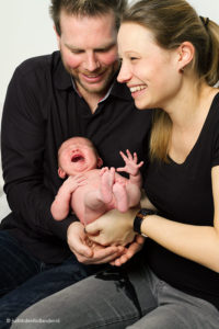 Familieportret | Portret van een jonge ouders met een baby op schoot | Fotografie Judith den Hollander (Hasselt, Maastricht, Haarlem).
