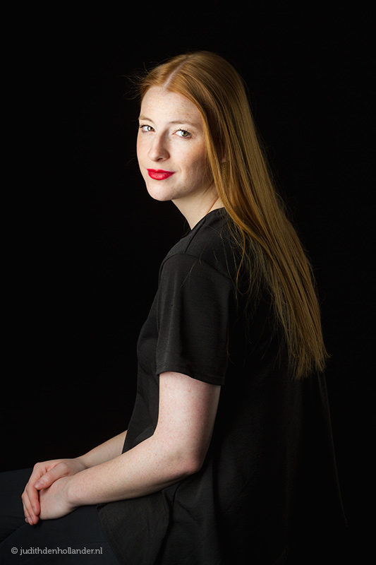 Klassiek portret van een jonge vrouw met lang rood haar tegen een donkere achtergrond | Fine art fotografie | Studio JDH, J. den Hollander. 